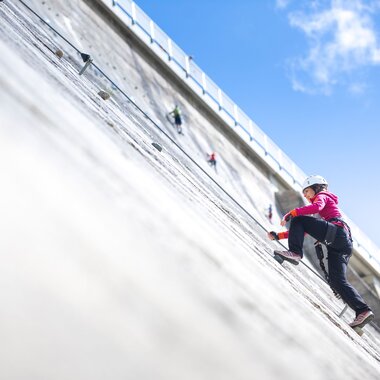 Kletterin die gerade den Klettersteig Silvrettasee hochklettert | © Golm Silvretta Lünersee Tourismus GmbH Bregenz, Stefan Kothner