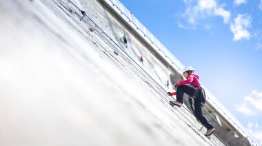Kletterin die gerade den Klettersteig Silvrettasee hochklettert | © Golm Silvretta Lünersee Tourismus GmbH Bregenz, Stefan Kothner
